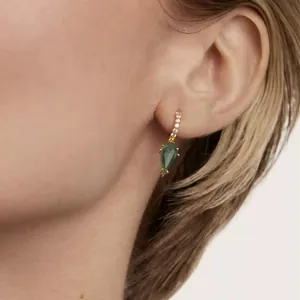Macro view of gold hoop earrings with green aquatic agate teardrop and pavé stones