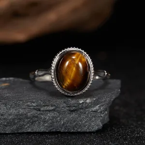 Macro detail of natural oval tiger's eye gemstone set in a vintage silver ring band.