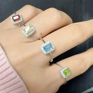 Variety of S925 sterling silver rings with colorful emerald-cut gemstones and halo.