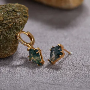 Macro detail of gold earrings with kite-shaped green moss agate stones.