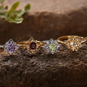 Makroaufnahme von vier Filigranringen mit Amethyst, Granat, Peridot und Citrin-Steinen.