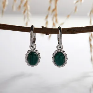 Close-up of S925 silver earrings with natural oval malachite and vintage texture