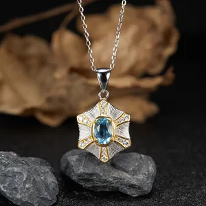 Dettaglio di un ciondolo in topazio blu montato in argento S925 su base di pietra naturale