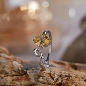 Macro-opname van een S925 zilveren ring met natuurlijke citrien en strikmotief.