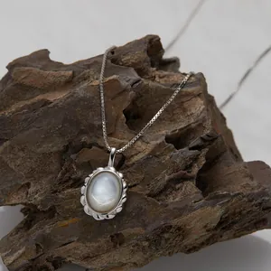 Close-up detail of vintage S925 sterling silver necklace with oval white shell pendant