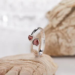 Dettaglio di un anello in argento sterling S925 con due eleganti granati a forma di cuore