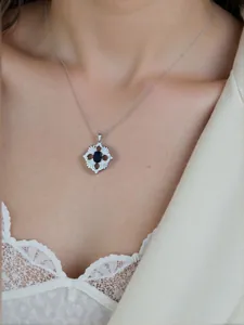 Detailansicht einer Halskette mit floralem Durchbruch-Anhänger und Edelstein