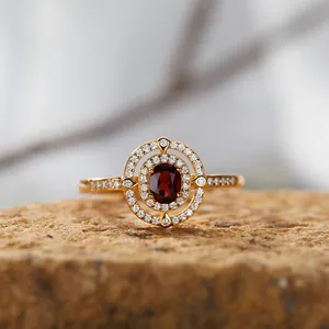 Detailaufnahme eines 18K vergoldeten S925 Silber Granatrings mit einem doppeltem Halo