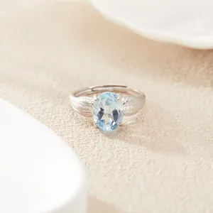 Vista dettagliata di un anello in argento sterling con topazio azzurro ovale e foglie
