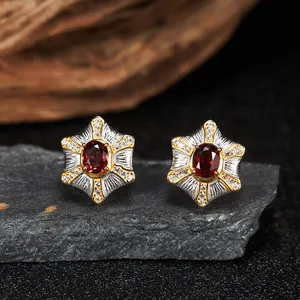 Dettaglio macro degli orecchini a forma di stella in argento 925 con granato rosso