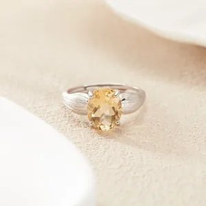 Dettaglio ravvicinato di un anello in argento S925 con citrino giallo ovale scintillante.