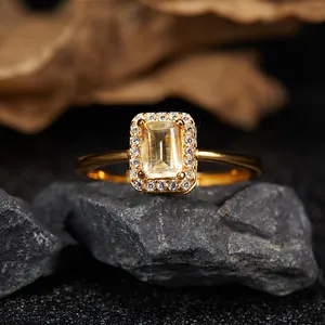 Detailed view of an emerald-cut yellow topaz ring with a sparkling halo setting.