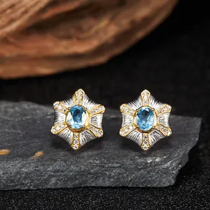 Primo piano di orecchini a stella in argento con topazio blu e pietre preziose