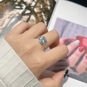 Primo piano di un elegante anello in argento S925 con una pietra di topazio blu ovale