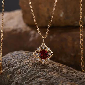 Nahaufnahme einer S925 Sterlingsilberkette mit einem Granatanhänger auf Natursteinen