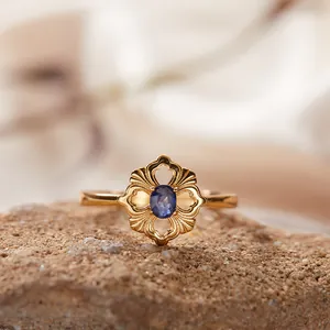 Makro-Detail eines Vintage-Ringes mit hohlem Blumendesign und blauem Apatit-Edelstein