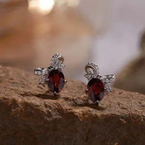 Macro view van S925 sterling zilveren strik oorbellen met natuurlijke granaatstenen