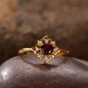 Detailansicht eines vintage vergoldeten Silberrings mit einem dunkelroten Granatstein.
