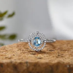 Makroansicht eines Silberrings mit blauem Saphir und doppeltem Halo-Besatz
