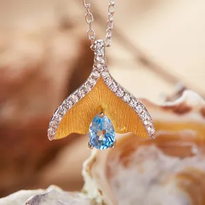 Detail van walvisstaart hanger met peervormige blauwe topaas en zirkonia