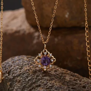 Makroansicht eines goldenen Halskettenanhängers mit einem violetten Amethyst-Edelstein