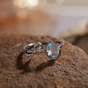 Elegante S925 zilveren ring met een fonkelende strik en grote ovale blauwe edelsteen.