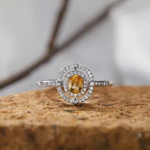 Nahaufnahme eines Rings aus Sterlingsilber mit gelbem Edelstein und doppeltem Halo
