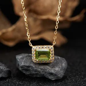 Macro view of gold-plated silver necklace featuring a green peridot pendant with halo