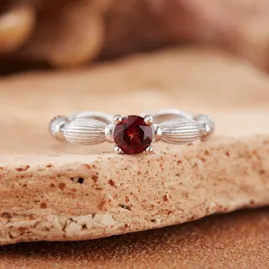 Detail view of natural round red garnet gemstone ring with textured S925 silver band