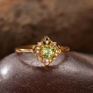 Nahaufnahme eines vergoldeten Sterlingsilberrings mit einem leuchtend grünen Peridot-Stein