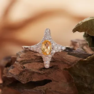 Dettaglio macro di un anello a stella in argento S925 con una gemma ovale di colore giallo.