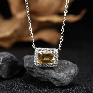 Close-up detail of sterling silver necklace featuring emerald cut citrine with halo stones