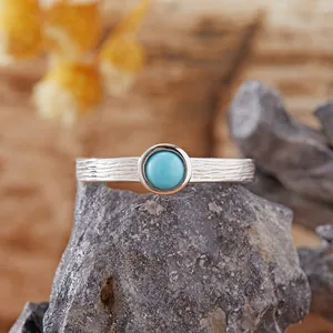 Primo piano di un anello in argento S925 con pietra turchese e trama a corteccia