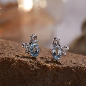 Macro-weergave van S925 sterling zilveren strik oorbellen met blauwe edelsteen