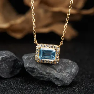 Macro detail of a rectangular blue topaz pendant with a sparkling halo on stones