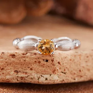 Detailed macro view of a silver ring featuring a round faceted yellow citrine gemstone