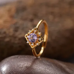 Detailansicht eines vintage vergoldeten Amethystrings auf einem strukturierten Stein