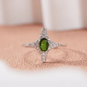 Primo piano dettagliato di un anello a stella in argento 925 con gemma verde ovale