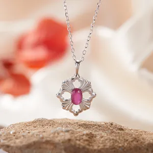 Nahaufnahme einer S925 Silberhalskette mit hohlgeformtem Blumenanhänger und rosa Edelstein.