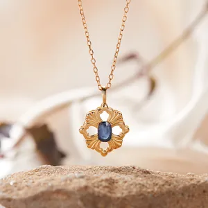 Nahaufnahme einer blauen Edelsteinkette mit filigranem goldenem Blumenanhänger