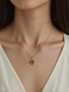 Nahaufnahme einer vergoldeten Halskette aus Sterlingsilber mit grünem Peridot-Anhänger.