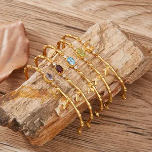 Detailed macro shot of gold bamboo-style bracelets set with vibrant natural gemstones