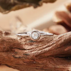 Detailed close-up of S925 silver bezel-set gemstone ring on natural wood texture