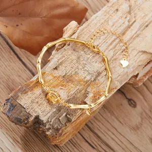 Detail of bamboo joint bracelet in S925 silver with a yellow gemstone and heart charm