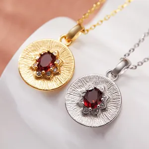 Close-up of vintage S925 silver coin pendants with red garnet and sparkling crystals