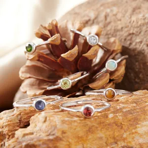 Dettaglio di vari anelli con pietre naturali tonde in montature in argento sterling S925