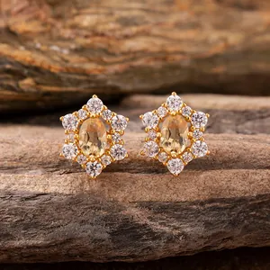 Macro view of sunflower-shaped stud earrings with yellow gemstones and clear zircon
