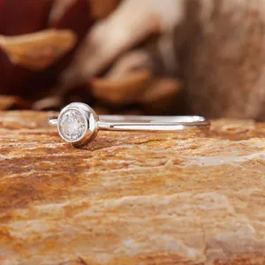 Primo piano di un anello in argento S925 minimalista con pietra rotonda incastonata