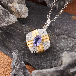 Detailed macro view of square silver pendant with purple tanzanite gemstone and gold accents