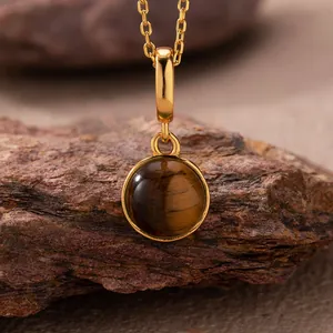 Detailed close-up showing the natural chatoyancy of a round tiger's eye stone pendant.